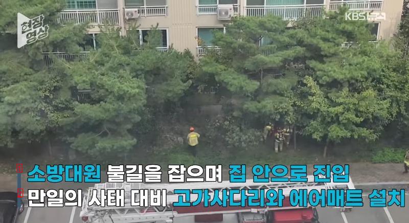 a girl hanging from a railing on the 11th floor of an apartment building