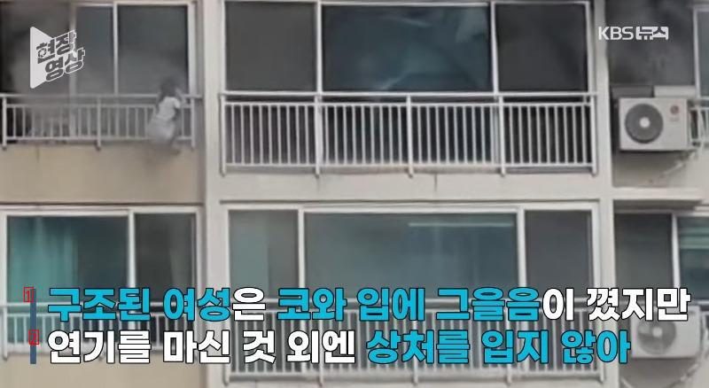 a girl hanging from a railing on the 11th floor of an apartment building