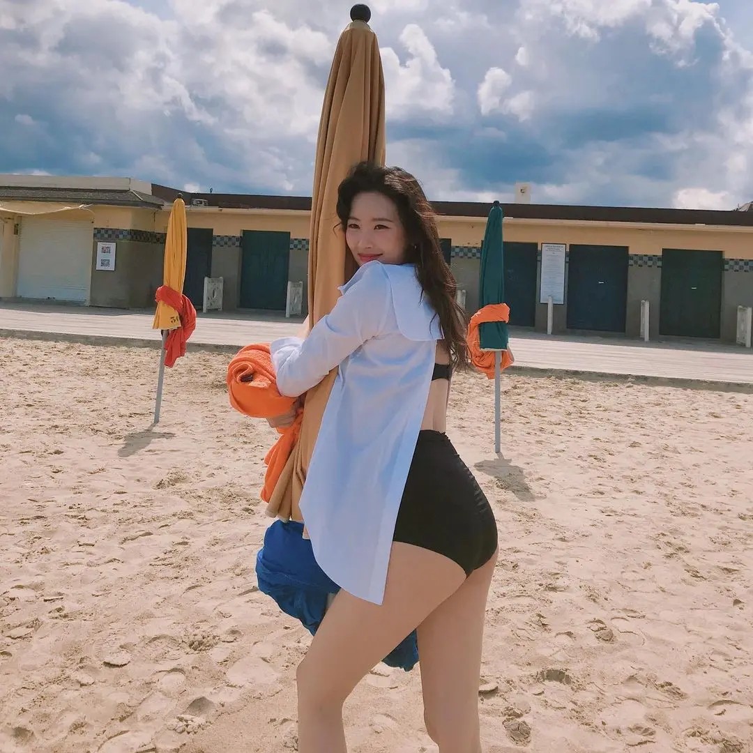 Sunmi's black bikini hipline hugging parasols at the beach