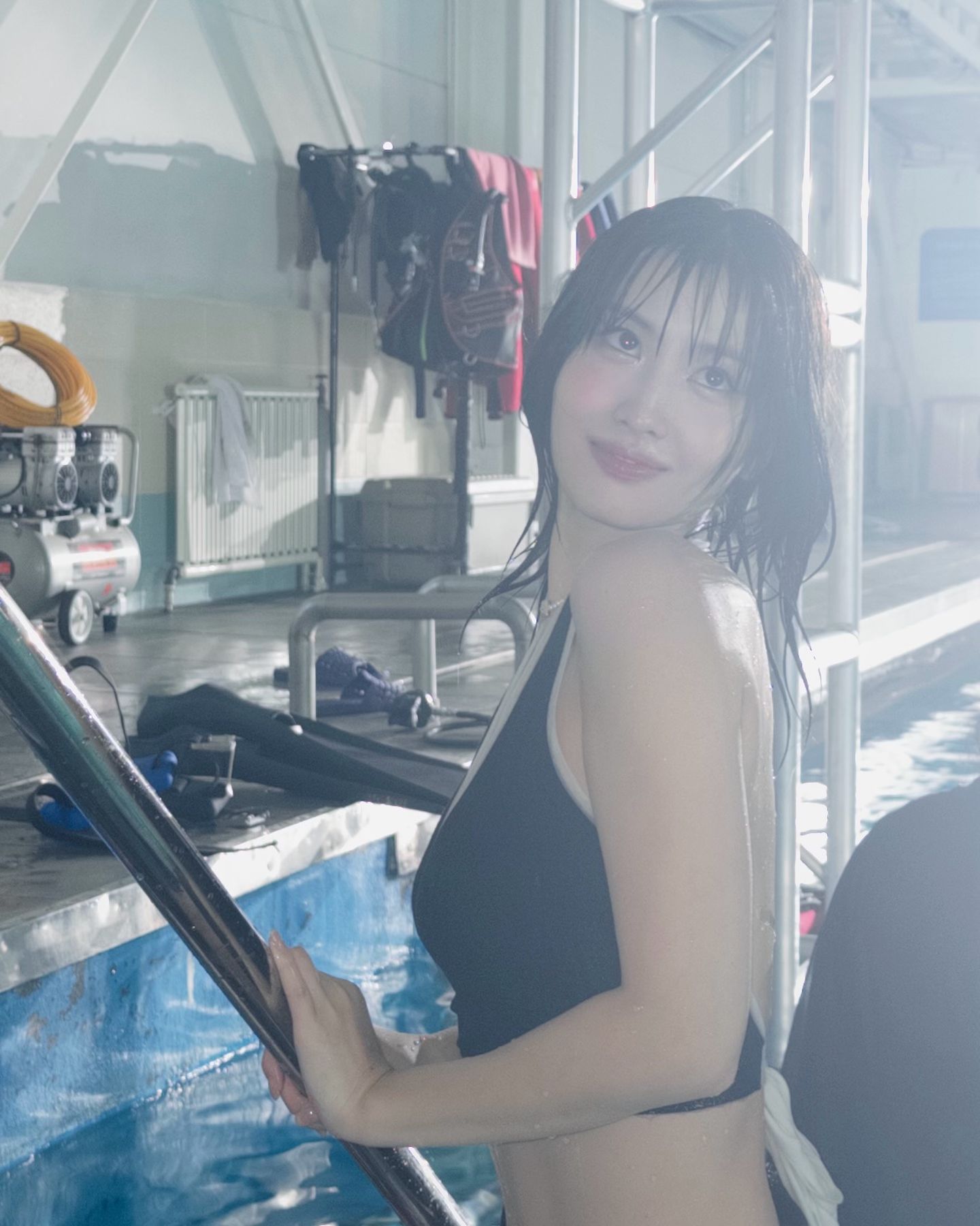 Twice Momo's black two-piece swimsuit with a solid body while scuba diving