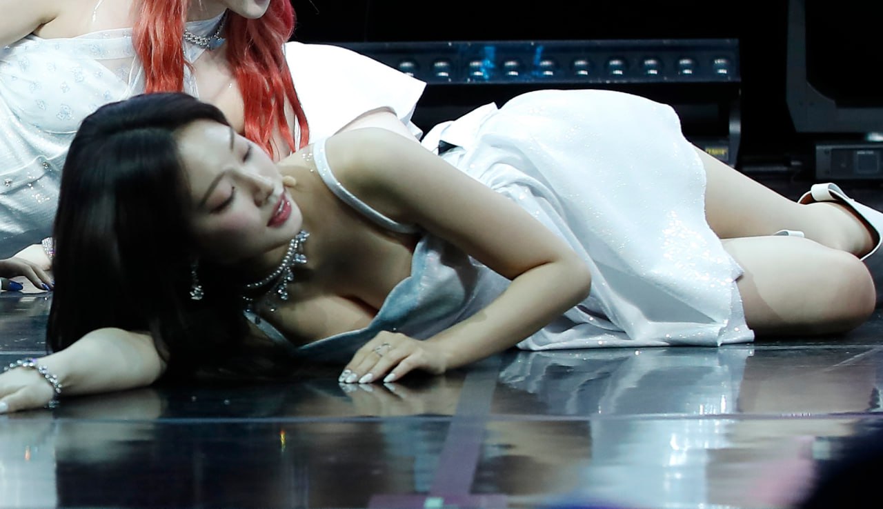 Weekly Joa lying down on stage in white one-piece dress exposing extra cleavage - Showcase