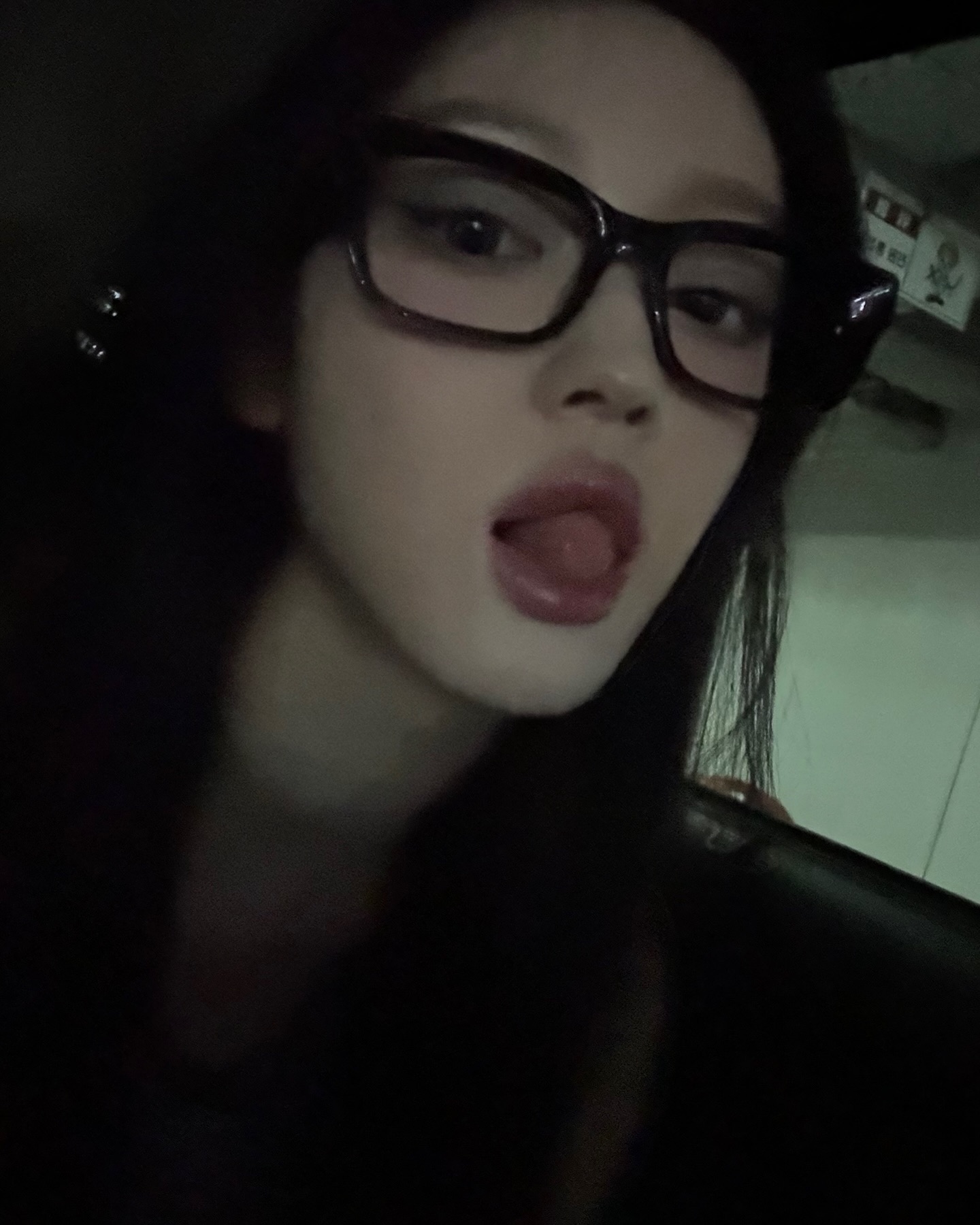 Oh My Girl's toddler wearing horn-rimmed glasses sticks out tongue with thick lips