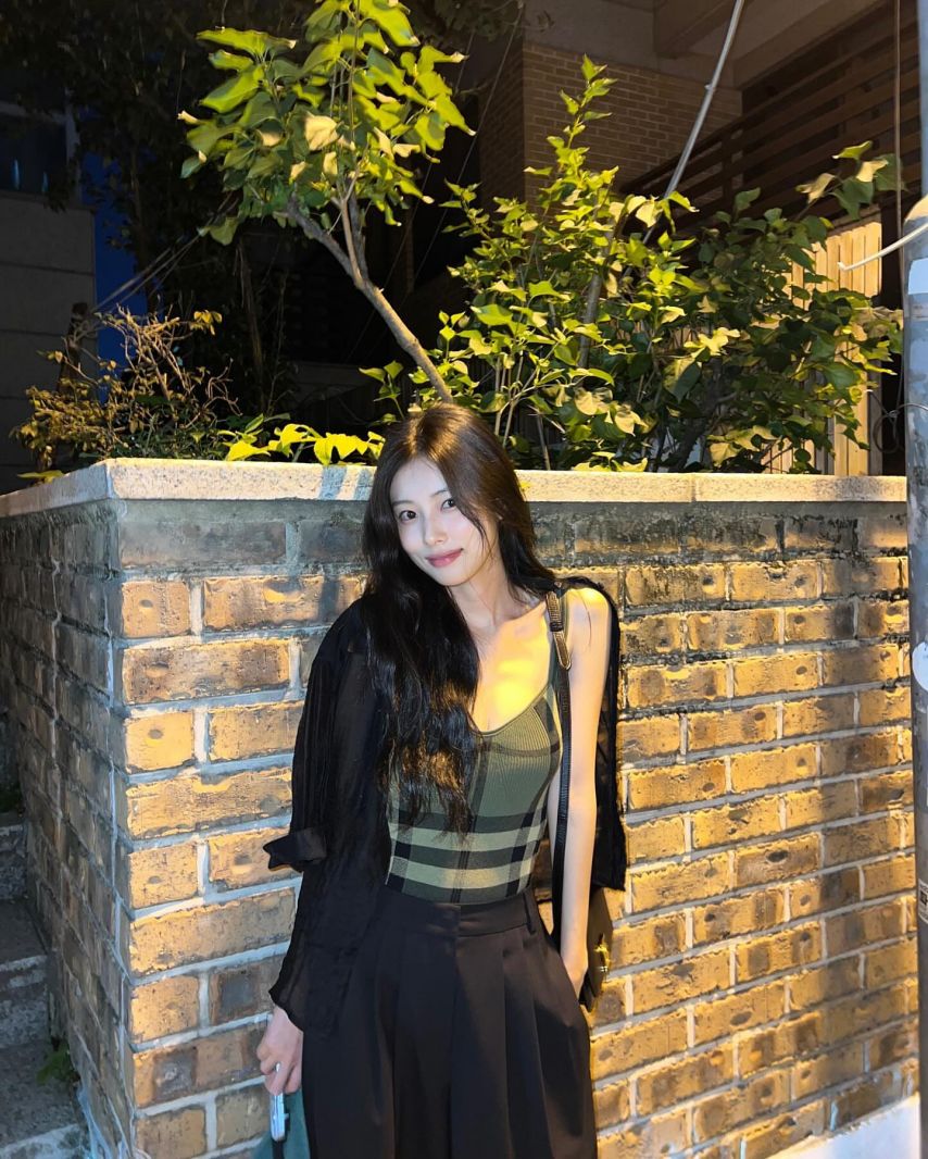 Hyewon Kang's cool green checked thong tank top subtly exposes her cleavage