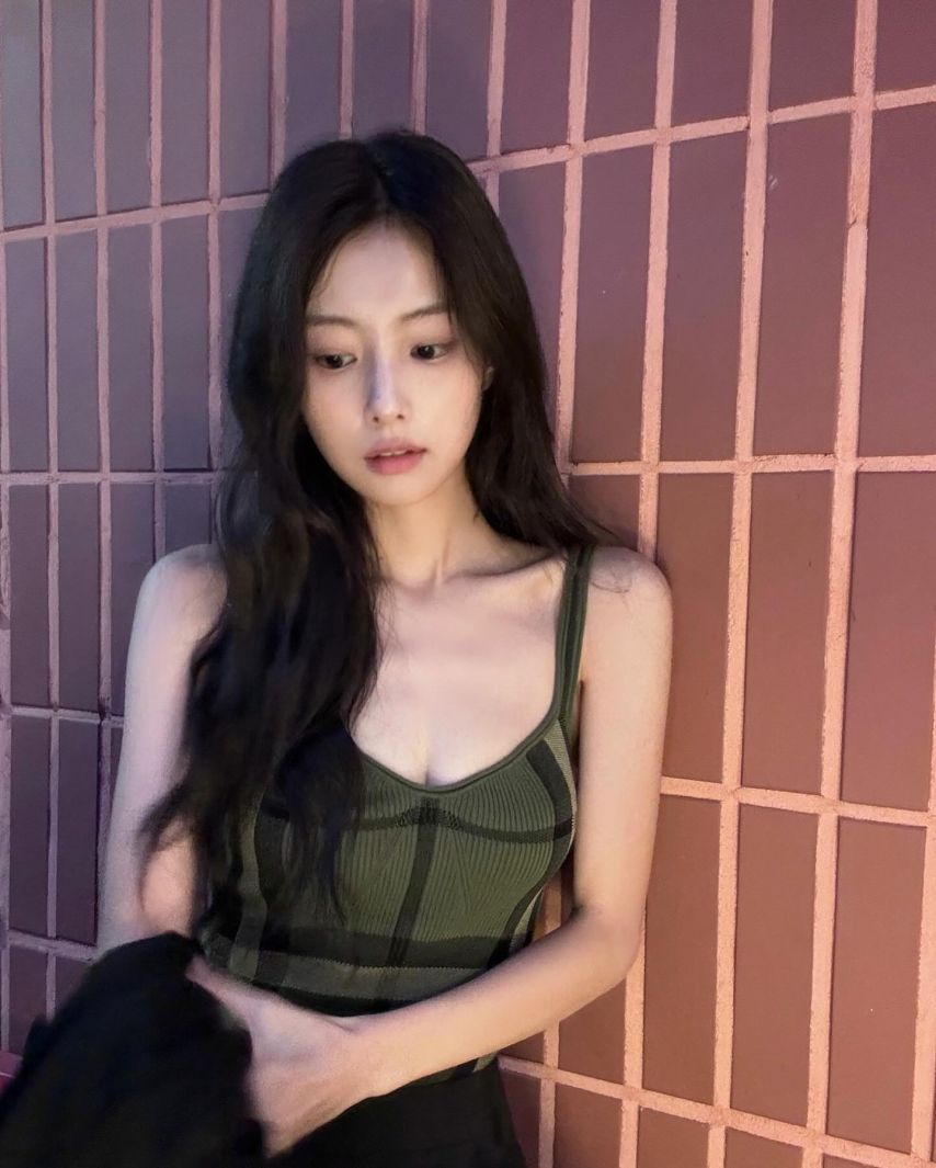 Hyewon Kang's cool green checked thong tank top subtly exposes her cleavage