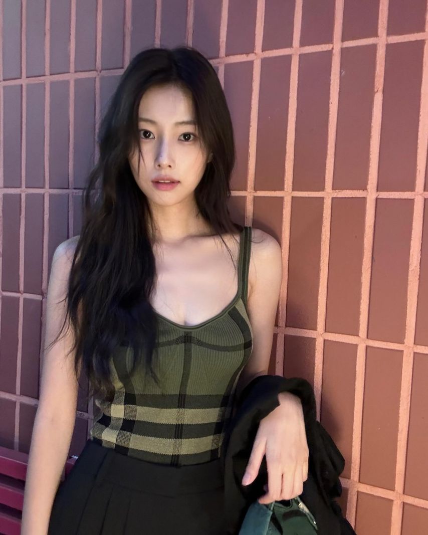 Hyewon Kang's cool green checked thong tank top subtly exposes her cleavage