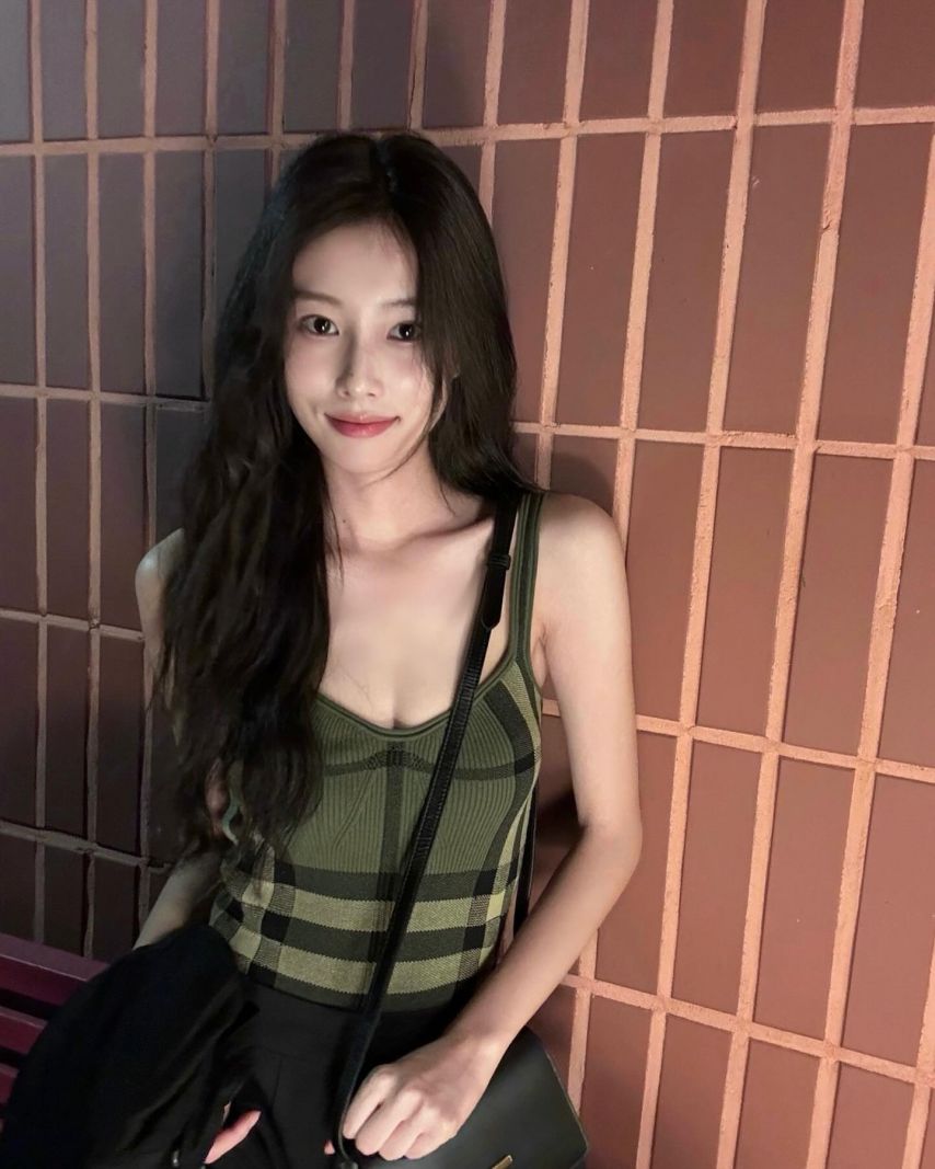 Hyewon Kang's cool green checked thong tank top subtly exposes her cleavage